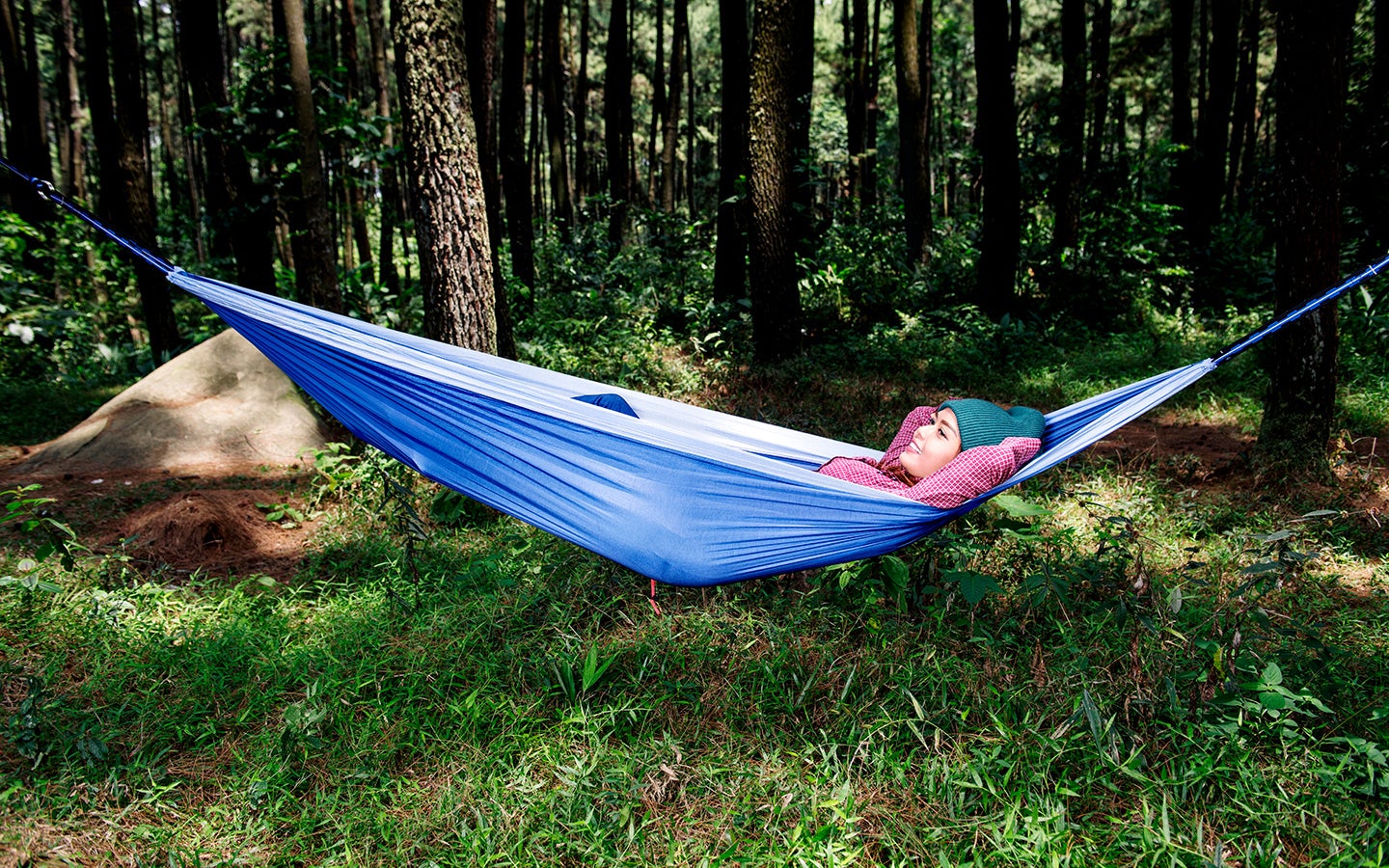 Woman relaxes in hammock in the woods