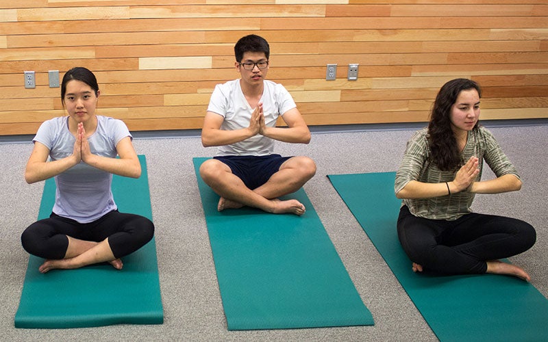 Three students doing yoga.