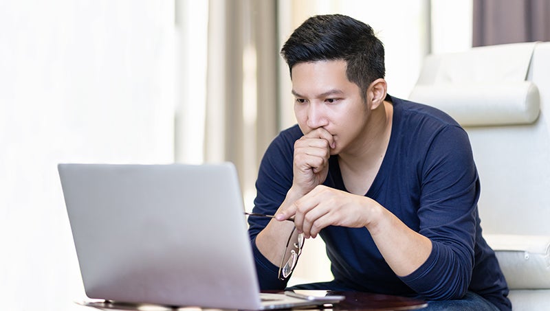 Young man watching videos on a laptop Young man watching videos on a laptop