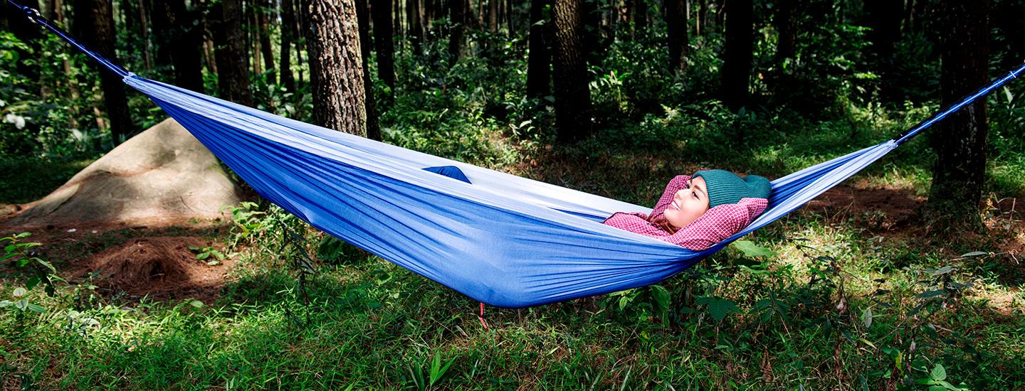 Woman relaxes in hammock in the woods